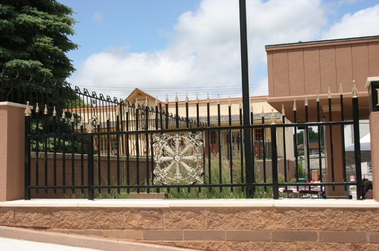 AmeriFence Corporation Wichita - Custom Iron Gate Fencing, 1229 Overscallop with quad flare & emblem